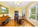 Bright bonus room features wood floors, a grand piano, and large windows at 16610 County Line Rd, Umatilla, FL 32784