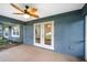 Covered patio with a ceiling fan, double doors and views of the backyard at 16610 County Line Rd, Umatilla, FL 32784