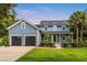 Charming two-story home with a well-manicured lawn, black garage doors, and inviting front porch at 16610 County Line Rd, Umatilla, FL 32784