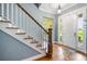 Inviting foyer features hardwood floors, staircase, and plenty of natural light shining through the front door at 16610 County Line Rd, Umatilla, FL 32784