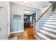 Bright foyer with hardwood floors, staircase, and views of the dining room, offering a welcoming entrance at 16610 County Line Rd, Umatilla, FL 32784