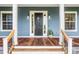 Beautiful front door with sidelights, wood porch and railings, and homey details at 16610 County Line Rd, Umatilla, FL 32784