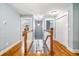 Upstairs hallway with hardwood floors, fresh paint, and natural light pouring in through the windows at 16610 County Line Rd, Umatilla, FL 32784
