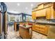 Bright kitchen offers wooden cabinets, stone counters, stainless appliances, and an island with a sink at 16610 County Line Rd, Umatilla, FL 32784