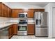 Modern kitchen with stainless steel appliances, wood cabinets and tile flooring at 16610 County Line Rd, Umatilla, FL 32784