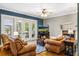Living room boasting natural light, cozy seating, wood flooring, a fireplace and exterior access at 16610 County Line Rd, Umatilla, FL 32784
