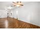 Open-concept living area with wood floors, ceiling fans, and access to the kitchen and hallway at 16610 County Line Rd, Umatilla, FL 32784