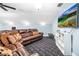 Spacious living room with a large leather couch, TV, and patterned carpet at 16610 County Line Rd, Umatilla, FL 32784