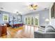 Spacious main bedroom with hardwood floors, ceiling fans, and French doors to a balcony at 16610 County Line Rd, Umatilla, FL 32784