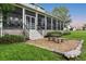Covered stone patio with screened walls, providing an inviting outdoor seating area at 16610 County Line Rd, Umatilla, FL 32784