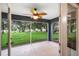 Covered patio showing a ceiling fan and a screened in view of a large, grassy yard at 16610 County Line Rd, Umatilla, FL 32784