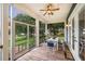 View from the screened-in porch featuring wood flooring, a ceiling fan, and outdoor seating at 16610 County Line Rd, Umatilla, FL 32784