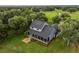 Aerial view of a blue two-story home with a screened-in porch and a fire pit area in backyard at 16610 County Line Rd, Umatilla, FL 32784