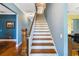 Elegant staircase with hardwood treads, white risers, and a classic wooden banister welcomes you at 16610 County Line Rd, Umatilla, FL 32784