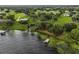Aerial view of a shoreline with a boat dock and lift on a tranquil lake surrounded by lush trees at 16610 County Line Rd, Umatilla, FL 32784