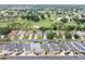 Aerial view of homes on a tree-lined street overlooking a golf course and pond in the distance at 16950 Se 80Th Bellavista Cir, The Villages, FL 32162