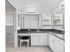 Bright bathroom featuring dual sinks, granite countertops, a large mirror, and white cabinets at 16950 Se 80Th Bellavista Cir, The Villages, FL 32162