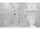 Bathroom featuring a marble glass-enclosed shower and toilet at 16950 Se 80Th Bellavista Cir, The Villages, FL 32162