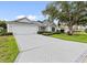 Well-maintained home with a brick driveway, manicured lawn, and mature landscaping at 16950 Se 80Th Bellavista Cir, The Villages, FL 32162