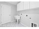 Laundry room featuring a utility sink and storage cabinets at 16950 Se 80Th Bellavista Cir, The Villages, FL 32162