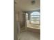 Well-lit bathroom features large garden tub with a window and a glass enclosed shower at 1784 Providence Blvd, Deltona, FL 32725