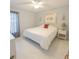 Neutral bedroom with white floors, fan, and a queen bed highlighted by modern accents and natural light at 1784 Providence Blvd, Deltona, FL 32725