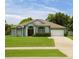 Charming one-story home with a well-maintained lawn, a paved driveway, and a two-car garage at 1784 Providence Blvd, Deltona, FL 32725