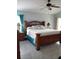 Spacious main bedroom featuring a decorative wooden headboard, ceiling fan, and light blue wall paint at 1784 Providence Blvd, Deltona, FL 32725