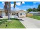 Inviting single-story home featuring a lush green lawn, mature trees, and a concrete driveway with beautiful landscaping at 1920 Dardanelle Dr, Orlando, FL 32808