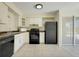 Functional kitchen with white cabinets, black appliances, tile flooring, and a view to the outside through a glass sliding door at 1920 Dardanelle Dr, Orlando, FL 32808