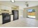 Bright kitchen with white cabinets, black appliances, and sliding glass doors leading to the backyard at 1920 Dardanelle Dr, Orlando, FL 32808