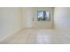Bright living room featuring neutral tile floors, a large window, and a freshly painted white door at 1920 Dardanelle Dr, Orlando, FL 32808