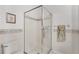 Bathroom featuring a glass door shower with white tile, and matching decorative wall trim at 2085 Stone Cross Cir, Orlando, FL 32828