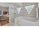 Bright bathroom featuring a tub and glass-enclosed shower with unique glass-block window at 2085 Stone Cross Cir, Orlando, FL 32828