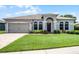 Well-maintained single-story home with lush green lawn and attached two car garage at 2085 Stone Cross Cir, Orlando, FL 32828