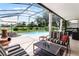 Relaxing screened-in patio featuring a pool and comfortable seating area with outdoor furniture at 2085 Stone Cross Cir, Orlando, FL 32828