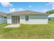 Home's back exterior showing a sliding door, lawn, and a small concrete patio at 2110 Mallard Creek Cir, Kissimmee, FL 34743