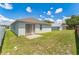 Spacious backyard with well-maintained lawn and a sliding door leading to a small patio area at 2110 Mallard Creek Cir, Kissimmee, FL 34743