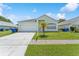 Charming single-story home with a well-manicured lawn, light-colored exterior, and attached garage at 2110 Mallard Creek Cir, Kissimmee, FL 34743