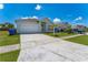 Front exterior view of home showing a two car garage, lawn, and sidewalk at 2110 Mallard Creek Cir, Kissimmee, FL 34743