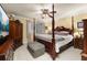 Bedroom featuring a four-poster bed, ceiling fan, television, and a cushioned ottoman at 2208 Mcmahon Ct # 1033, Orlando, FL 32812