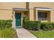 Close-up of a townhouse's entrance with a decorative green door, number, and manicured hedge at 2208 Mcmahon Ct # 1033, Orlando, FL 32812