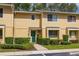Townhouse exterior with a green front door, manicured shrubs, and a well-maintained lawn at 2208 Mcmahon Ct # 1033, Orlando, FL 32812
