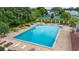 A bright blue pool area with deck chairs and mature trees for sun and shade at 2208 Mcmahon Ct # 1033, Orlando, FL 32812