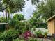 Overview of the backyard featuring a deck, lush garden with tropical foliage, and a peaceful, private setting at 2320 E Crystal Lake Ave, Orlando, FL 32806