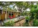 Backyard of charming home with deck, lush greenery, and comfortable seating at 2320 E Crystal Lake Ave, Orlando, FL 32806