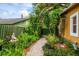 Landscaped backyard with stone walkway, leading to a wooden gate, and framed by lush greenery and mature trees at 2320 E Crystal Lake Ave, Orlando, FL 32806