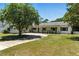 Charming one-story home with manicured lawn and mature trees, offering serene curb appeal with a concrete driveway at 2350 Derbyshire Rd, Maitland, FL 32751