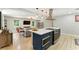 Modern kitchen with a breakfast bar island, stainless steel appliances, and adjacent living area at 2350 Derbyshire Rd, Maitland, FL 32751