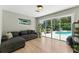 Cozy living room with hardwood floors, large sliding glass doors leading to a private pool area at 2350 Derbyshire Rd, Maitland, FL 32751